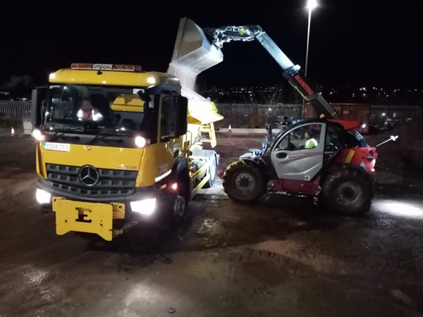 A gritting lorry being filled with grit