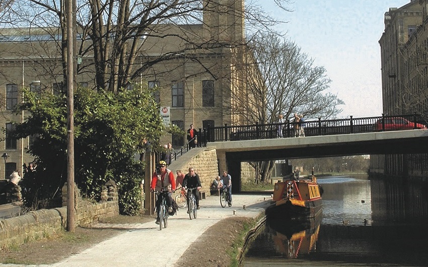 A group of cyclists on the canal tow path at Saltaire.