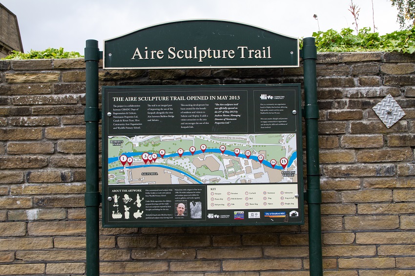 A notice board with a poster for the Aire Sculpture Trail.